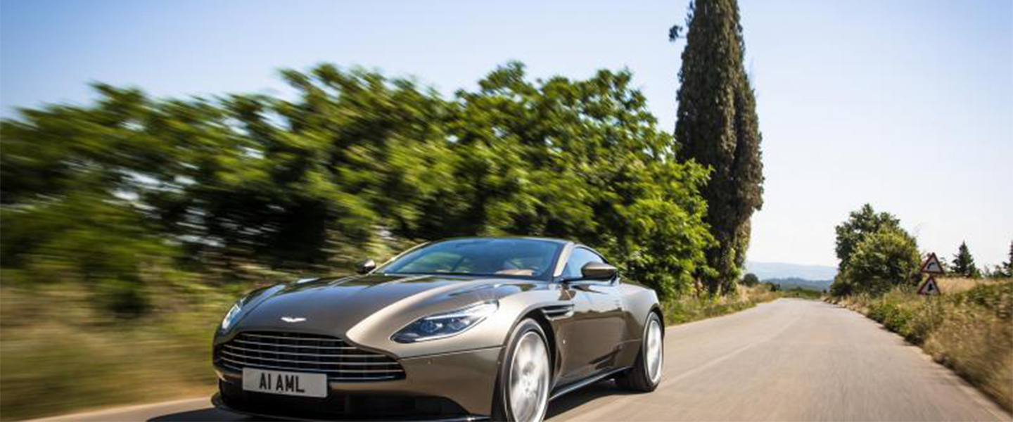 Aston martin driving on a road in the sun