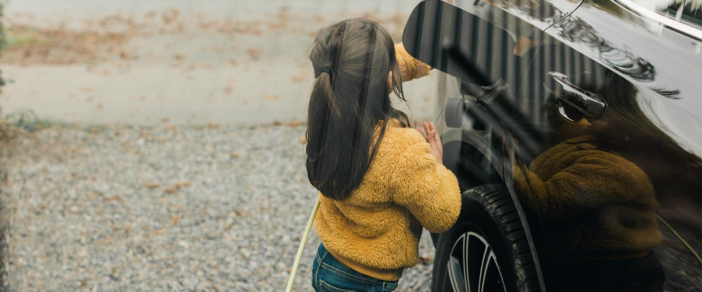 Girl plugging electric charger in to car