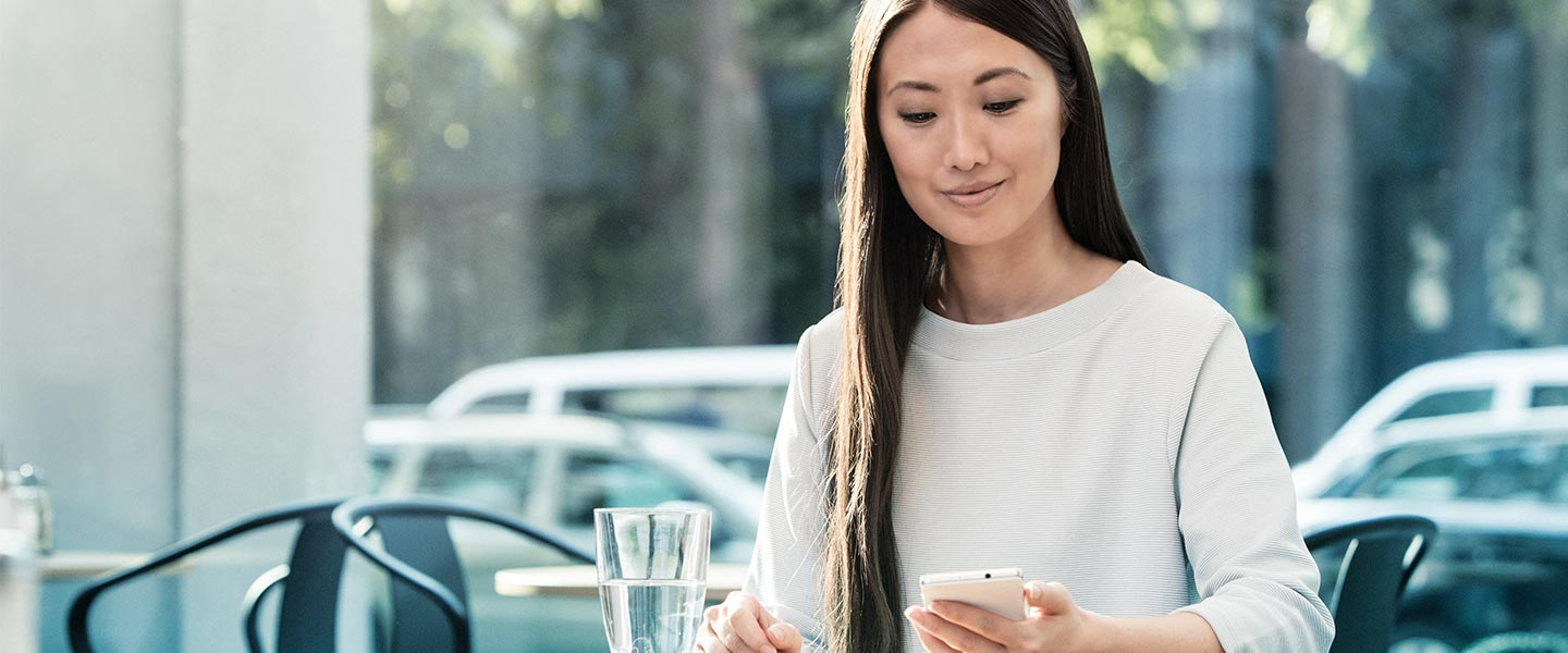 Woman sitting in cafe looking at phone