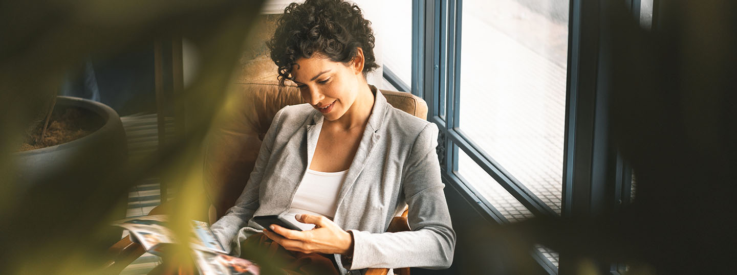 A relaxed businesswoman taking a moment to look at her phone