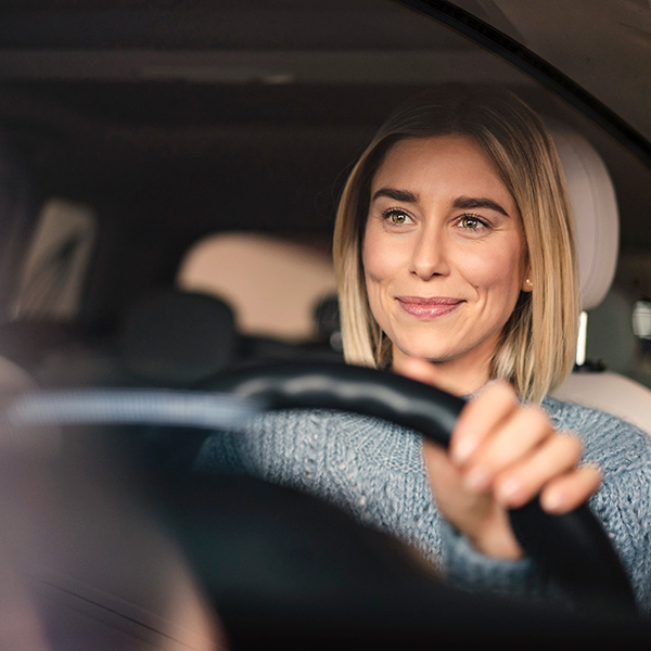 Close up of woman smiling while driving her car