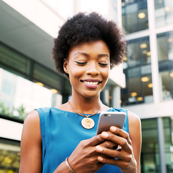 Woman standing in front of a building looking at her phone