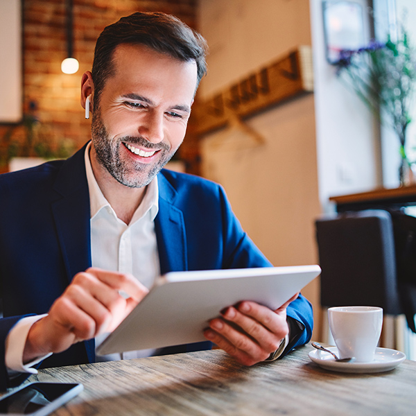 Man in suit working in a cafe with his ipad