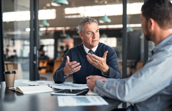 Man gesturing enthusiastically while explaining something to another man