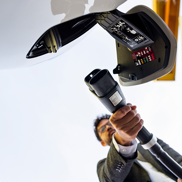 Man plugging in an electric car to charge